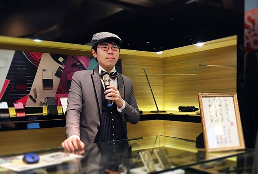 韓玉青於誠品信義書寫美學講座現場,身旁展示個人書法作品與書寫收藏