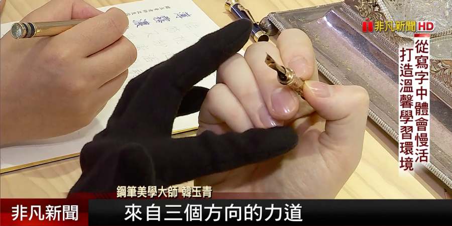 韓玉青以手部示範說明握筆時不同方向的施力